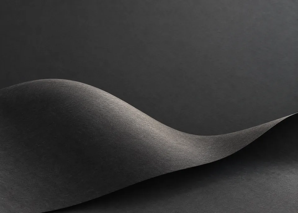Graphite Wave: A single wide charcoal paper sheet forms a shallow rolling wave across lower half, soft pewter highlights and smooth graphite backdrop.