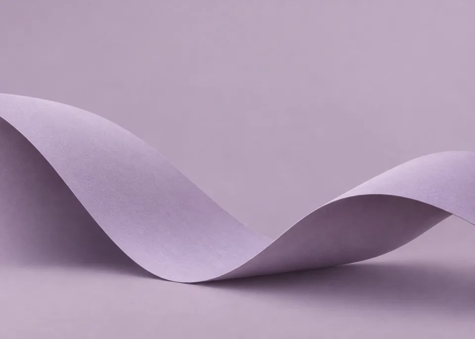 Lilac Ribbon: One wide matte lilac paper ribbon makes a low gentle S-fold across lower two thirds, pale mauve background, softly illuminated edges.